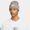 Ein Mann in einer grauen Nike-Mütze mit Logo und einem weißen T-Shirt mit Aufdruck.
