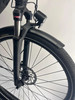 Vorderseite eines schwarzen E-Bikes mit Stoßdämpfer, Licht und Schutzblech.