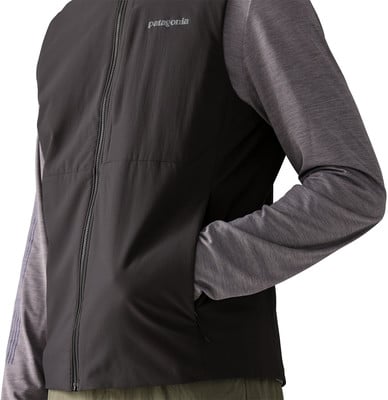 Mann in dunkler Patagonia-Jacke mit grauen Ärmeln, Hand in Tasche. Mann in dunkler Patagonia-Jacke mit grauen Ärmeln, Hand in Tasche.