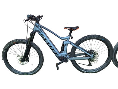 Graues Fully-Elektrofahrrad von Scott mit orangefarbenem Sattel auf weißem Hintergrund. Graues Fully-Elektrofahrrad von Scott mit orangefarbenem Sattel auf weißem Hintergrund.