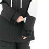 Eine Hand steckt eine Karte in die Ärmeltasche einer schwarzen Jacke.
