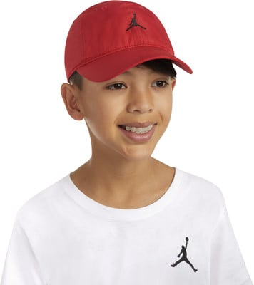 Junge mit roter Kappe und weißem T-Shirt mit Jordan-Logo. Junge mit roter Kappe und weißem T-Shirt mit Jordan-Logo.