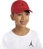 Junge mit roter Kappe und weißem T-Shirt mit Jordan-Logo.