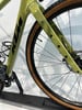 Detail des Rahmens eines grünen KTM Gravelbikes mit schwarzem Logo und Vorderrad.