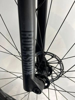 Detail einer RockShox Mountainbike-Federgabel mit Scheibenbremse und Speichen. Detail einer RockShox Mountainbike-Federgabel mit Scheibenbremse und Speichen.