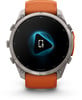 Garmin Smartwatch mit orangefarbenem Armband und Mikrofon-Symbol auf dem Display.