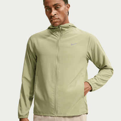 Ein Mann in einer grünen Nike-Kapuzenjacke mit der Hand in der Tasche. Ein Mann in einer grünen Nike-Kapuzenjacke mit der Hand in der Tasche.