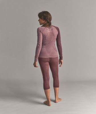 Eine Frau in einem rosafarbenen Langarmshirt und 3/4-Leggings. Eine Frau in einem rosafarbenen Langarmshirt und 3/4-Leggings.