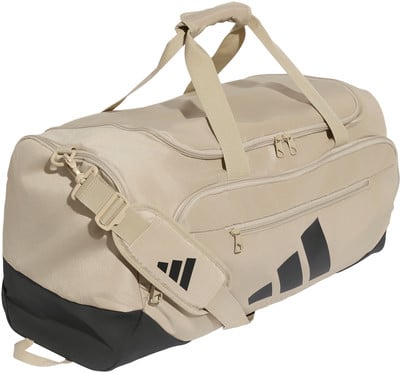 Beige Adidas Sporttasche mit schwarzen Streifen und Riemen. Beige Adidas Sporttasche mit schwarzen Streifen und Riemen.