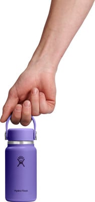 Eine Hand hält eine lila Hydro Flask Flasche am Griff. Eine Hand hält eine lila Hydro Flask Flasche am Griff.