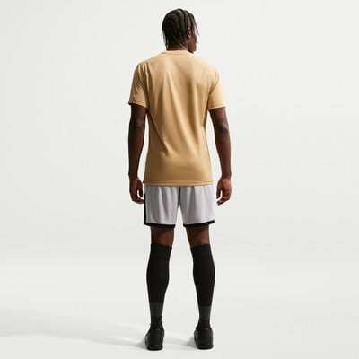 Ein Mann in einem beigen T-Shirt und grauen Shorts steht mit dem Rücken zur Kamera. Ein Mann in einem beigen T-Shirt und grauen Shorts steht mit dem Rücken zur Kamera.