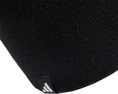 Schwarze Mütze mit weißem Adidas-Logo auf Etikett. Schwarze Mütze mit weißem Adidas-Logo auf Etikett.