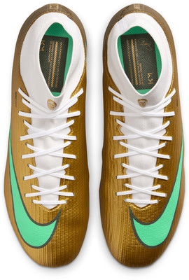 Goldene Fußballschuhe mit weißen Schnürsenkeln und grünem Nike-Swoosh. Goldene Fußballschuhe mit weißen Schnürsenkeln und grünem Nike-Swoosh.