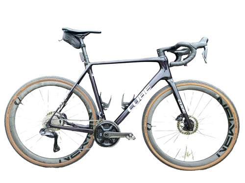 Dunkelviolettes Cube Gravelbike mit braunen Reifen und schwarzem Sattel.