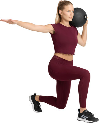 Eine Frau in Leggings macht einen Ausfallschritt mit einem Medizinball Eine Frau in Leggings macht einen Ausfallschritt mit einem Medizinball
