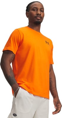Mann in einem orangefarbenen T-Shirt und weißen Shorts mit Under Armour Logo.