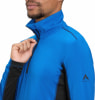 Ein Mann schließt eine blaue McKinley-Jacke mit schwarzen Details am Reißverschluss am Hals.