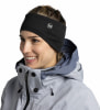 Eine Frau trägt ein schwarzes Stirnband mit Buff-Logo und eine graue Winterjacke.