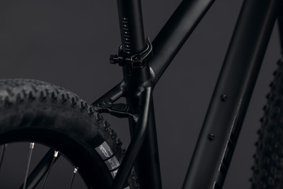 Detail des Rahmens eines schwarzen Mountainbikes mit Reifen und Sattelstütze.