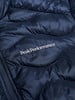 Detail einer dunkelblauen Steppjacke mit Peak Performance Logo.