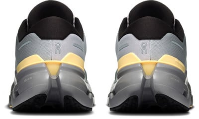 Rückansicht eines Paares grauer Laufschuhe mit gelben Akzenten.
