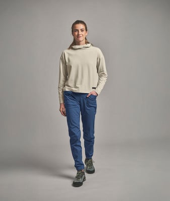 Eine Frau in einem beigen Hoodie und blauer Hose geht auf Sie zu. Eine Frau in einem beigen Hoodie und blauer Hose geht auf Sie zu.