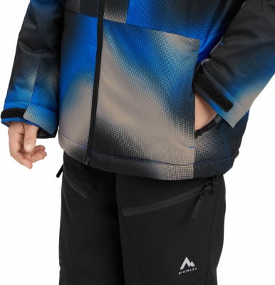 Ein Kind trägt eine Winterjacke mit blau-grauem Muster und eine schwarze Hose.
