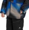 Ein Kind trägt eine Winterjacke mit blau-grauem Muster und eine schwarze Hose.