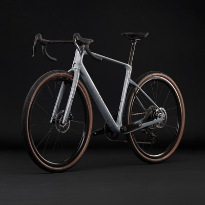 Graues Gravelbike mit braunen Reifen vor schwarzem Hintergrund. Graues Gravelbike mit braunen Reifen vor schwarzem Hintergrund.
