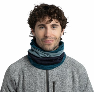 Ein Mann mit lockigem Haar trägt einen grauen Pullover und einen bunten Schal. Ein Mann mit lockigem Haar trägt einen grauen Pullover und einen bunten Schal.