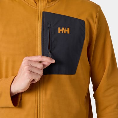 Egy férfi a kabátján lévő HH logós zsebébe nyúl.