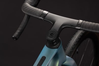 Detail eines modernen Carbonlenkers an einem Fahrrad mit blaugrünem Rahmen. Detail eines modernen Carbonlenkers an einem Fahrrad mit blaugrünem Rahmen.