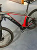 Graues Trek Mountain-E-Bike mit roten Akzenten und schwarzen Rädern.