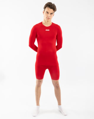 Junger Mann in einem roten Langarmshirt und Shorts Junger Mann in einem roten Langarmshirt und Shorts