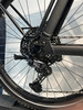 Detail des hinteren Schaltwerks und der Kassette an einem schwarzen Fahrrad.