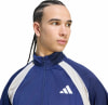 Mann in dunkelblauer Jacke mit weißen Streifen und Adidas-Logo.
