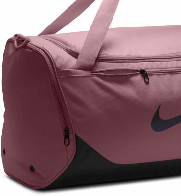 Eine rosafarbene Nike Sporttasche mit schwarzem Logo und Reißverschlüssen. Eine rosafarbene Nike Sporttasche mit schwarzem Logo und Reißverschlüssen.