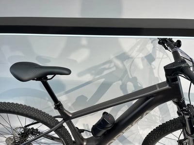 Ein schwarzes E-Bike mit schwarzem Sattel und Licht darüber. Ein schwarzes E-Bike mit schwarzem Sattel und Licht darüber.