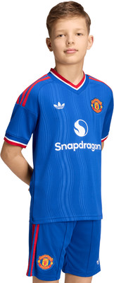 Junge im blauen Manchester United Trikot mit Snapdragon-Logo und roten Streifen. Junge im blauen Manchester United Trikot mit Snapdragon-Logo und roten Streifen.