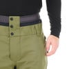 Detail einer grünen Herren-Skihose mit schwarzem Oberteil und Knöpfen.