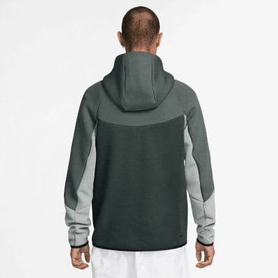 Rückansicht eines Mannes in einem dunkelgrauen Nike Tech Fleece Hoodie.