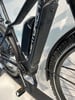 Schwarzes E-Mountainbike mit großem Akku und Federung.