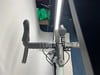 Nahaufnahme eines Fahrradlenkers mit Vorderlicht und Bremshebeln.