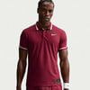 Ein Mann in einem dunkelroten Nike Poloshirt mit weiß gestreiftem Kragen und Ärmeln.