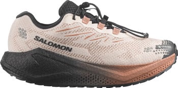 Beige Salomon Laufschuh mit schwarzer Sohle und orangefarbenen Details.