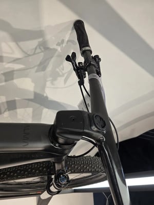 Detail des Lenkers und der Vorderseite eines Mountainbikes mit sichtbarem Logo Detail des Lenkers und der Vorderseite eines Mountainbikes mit sichtbarem Logo