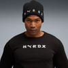 Ein Mann in einem schwarzen T-Shirt und einer Mütze mit HYROX-Logo.
