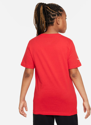Mädchen in einem roten T-Shirt mit Zopf und weißem Nike-Logo auf dem Ärmel. Mädchen in einem roten T-Shirt mit Zopf und weißem Nike-Logo auf dem Ärmel.