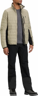 Ein Mann in einer beige gesteppten Jacke und schwarzer Hose mit Wanderschuhen. Ein Mann in einer beige gesteppten Jacke und schwarzer Hose mit Wanderschuhen.