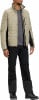 Ein Mann in einer beige gesteppten Jacke und schwarzer Hose mit Wanderschuhen.